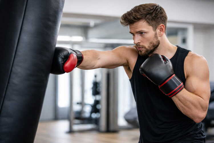 Boxsack Training im Fitnessstudio – Mann trainiert Boxtechnik und Schlagkraft am professionellen Boxsack.